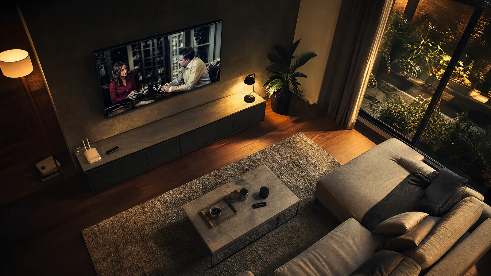 Wohnzimmer ohne Kabelbox und Satellitenschüssel mit Smart-TV an der Wand und WLAN-Router im Regal